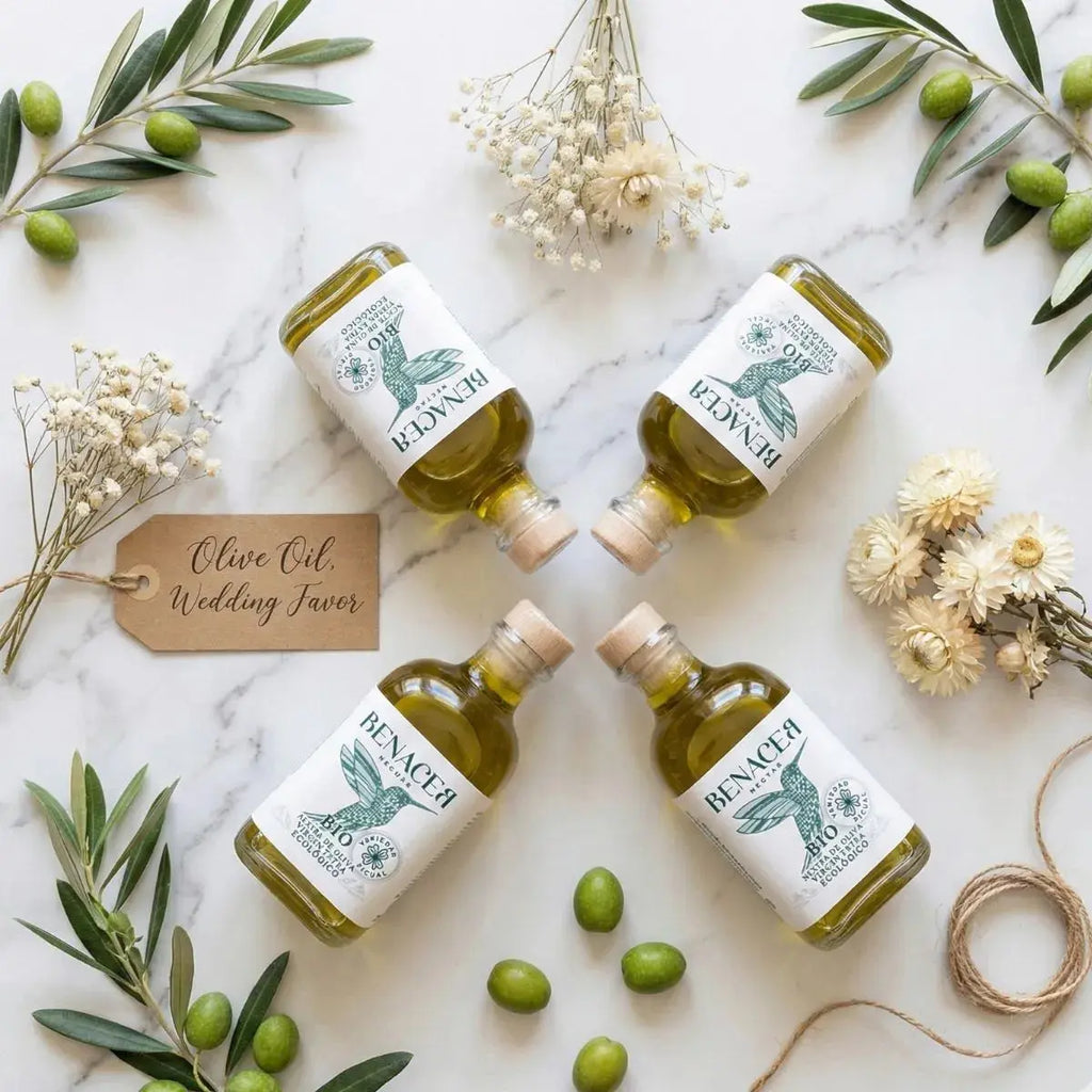 Composición de frascas de aceite de oliva ecológico con ramas de olivo y flores para detalles de boda